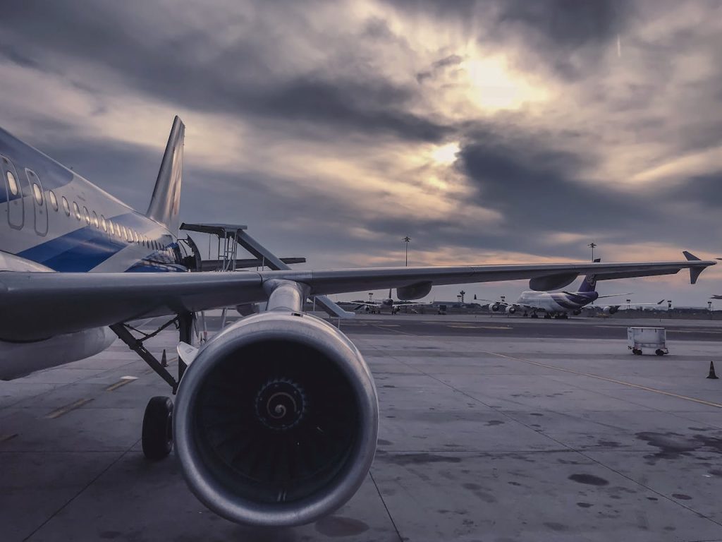 pexels-photo-912050 A passenger airplane is parked on the tarmac at sunset, with another aircraft in the background.